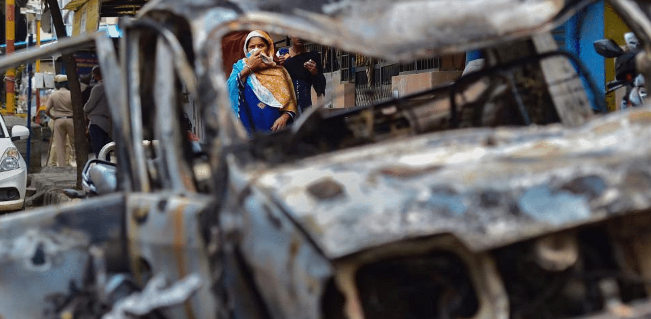 Charred remains of a vehicle vandalised by a mob over a social media post, allegedly by a relative of a Congress MLA, in Bengaluru, Wednesday, Aug. 12, 2020. Credit: PTI Photo