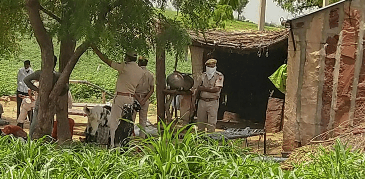 Policemen inspect the site where eleven members of a family of Pakistan Hindu migrants were found dead at a farm, in Jodhpur district, Sunday, Aug. 9, 2020. Credit: PTI Photo