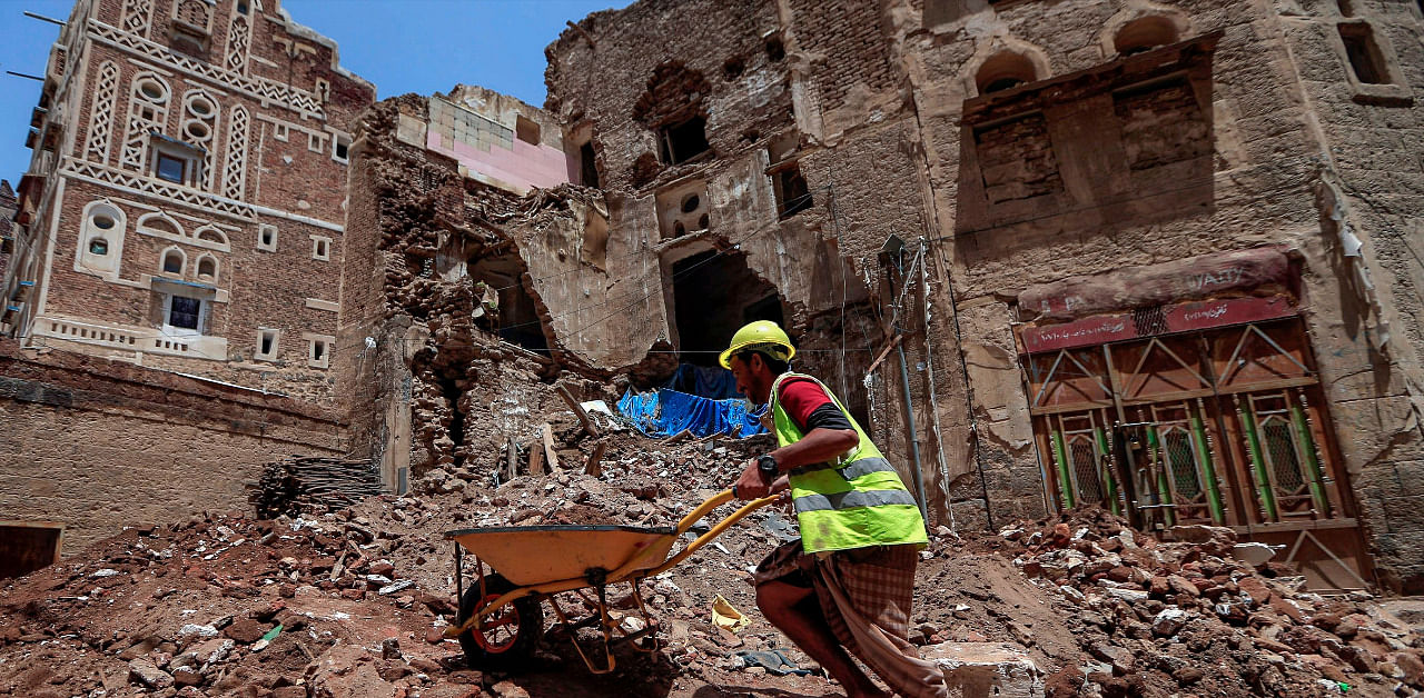 Yemeni labourers remove the rubble ahead of restoration works on the site of a collapsed UNESCO-listed building following heavy rains, in the old city of the Yemeni capital Sanaa. Credit: AFP Photo
