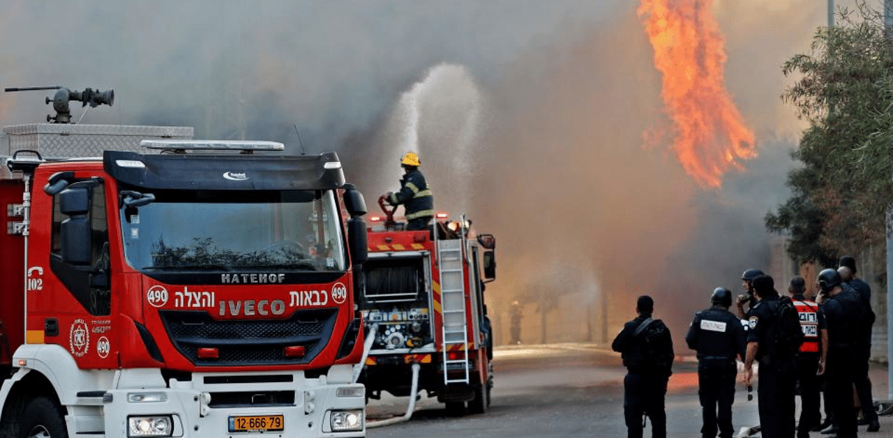 Israeli firefighter trucks douse a burning factory in the southern Israeli town of Sderot, after it was reportedly hit with rockets fired from the Gaza Strip on November 12, 2019.. Credit: AFP Photo