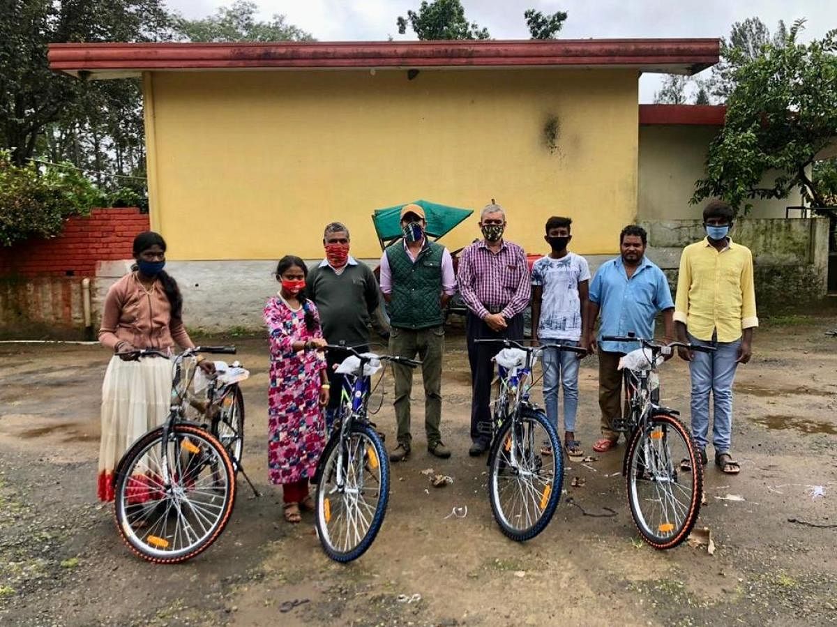 Planters and father-son duo Vinod Sivappa and Vishal Sivappa donated bicycles to the needy workers and students. DH Photo