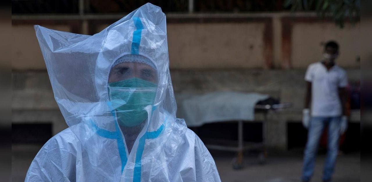 A medical worker wears personal protective equipment (PPE) and a plastic bag over his head as he transports the body of a patient who was suspected to have died of COVID-19, at Jawahar Lal Nehru Medical College and Hospital, during the coronavirus, in Bhagalpur, Bihar, India, July 27, 2020. Credit: Reuters