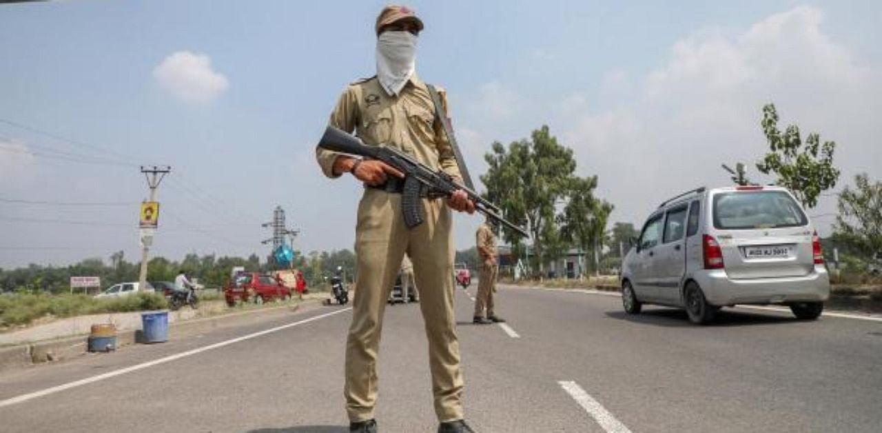 Police personnel stand guard on Jammu highway. Credit: PTI