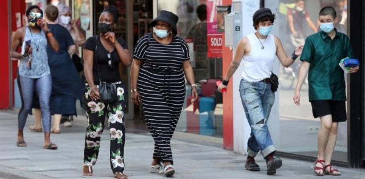 People wear face masks as they walk on a street in Brussels. Credit: AFP