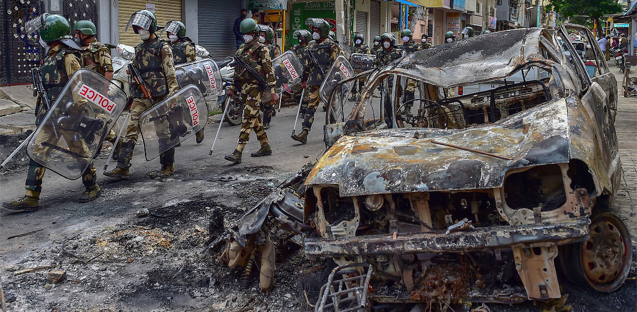 Security personnel carry out a flag march in the riot-hit area after a mob went on a rampage on Tuesday over a social media post, allegedly posted by a Congress MLA's relative, in Bengaluru. Credit: PTI