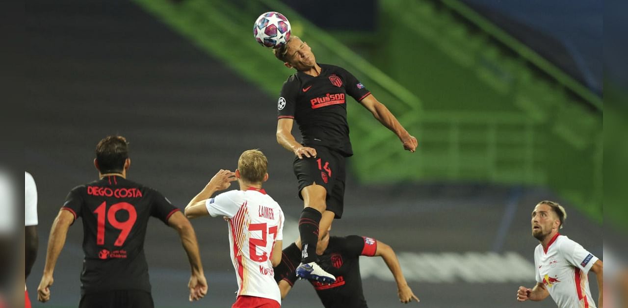 Atletico Madrid's Marcos Llorente jumps for a header next to Leipzig's Konrad Laimer during the Champions League quarterfinal match between RB Leipzig and Atletico Madrid at the Jose Alvalade stadium in Lisbon. Credit: AP/PTI Photo