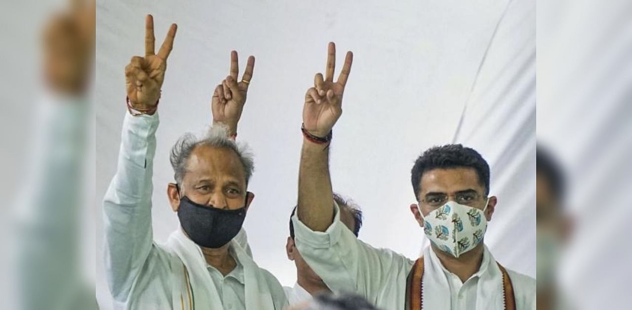 Rajasthan Chief Minister Ashok Gehlot (left) and senior Congress leader Sachin Pilot flash victory signs during the party MLAs' meeting, at the Chief Minister's residence in Jaipur. Credit: PTI