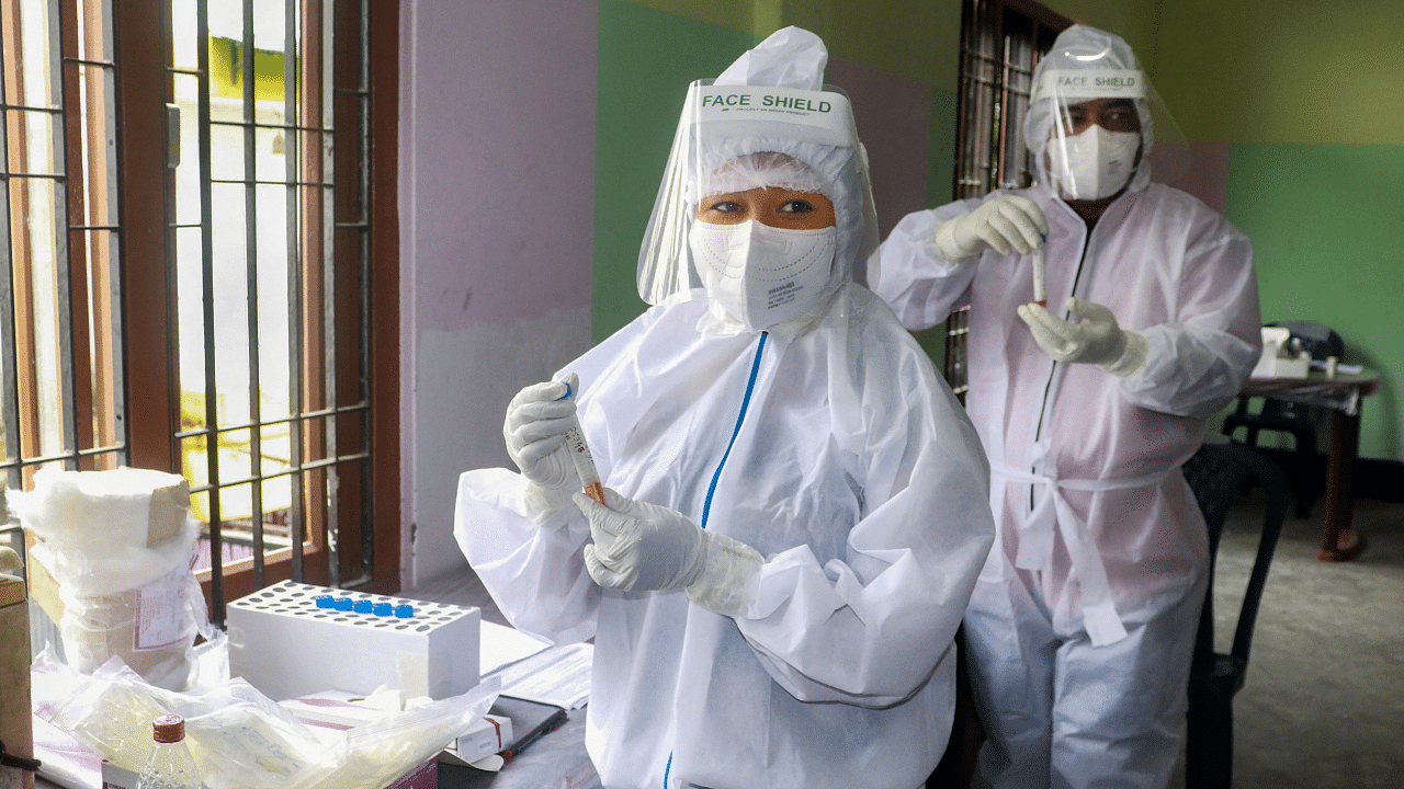 Health workers wearing PPE hold samples for Covid-19 rapid antigen testing, at Tezpur in Sonitpur district. Credits: PTI Photo