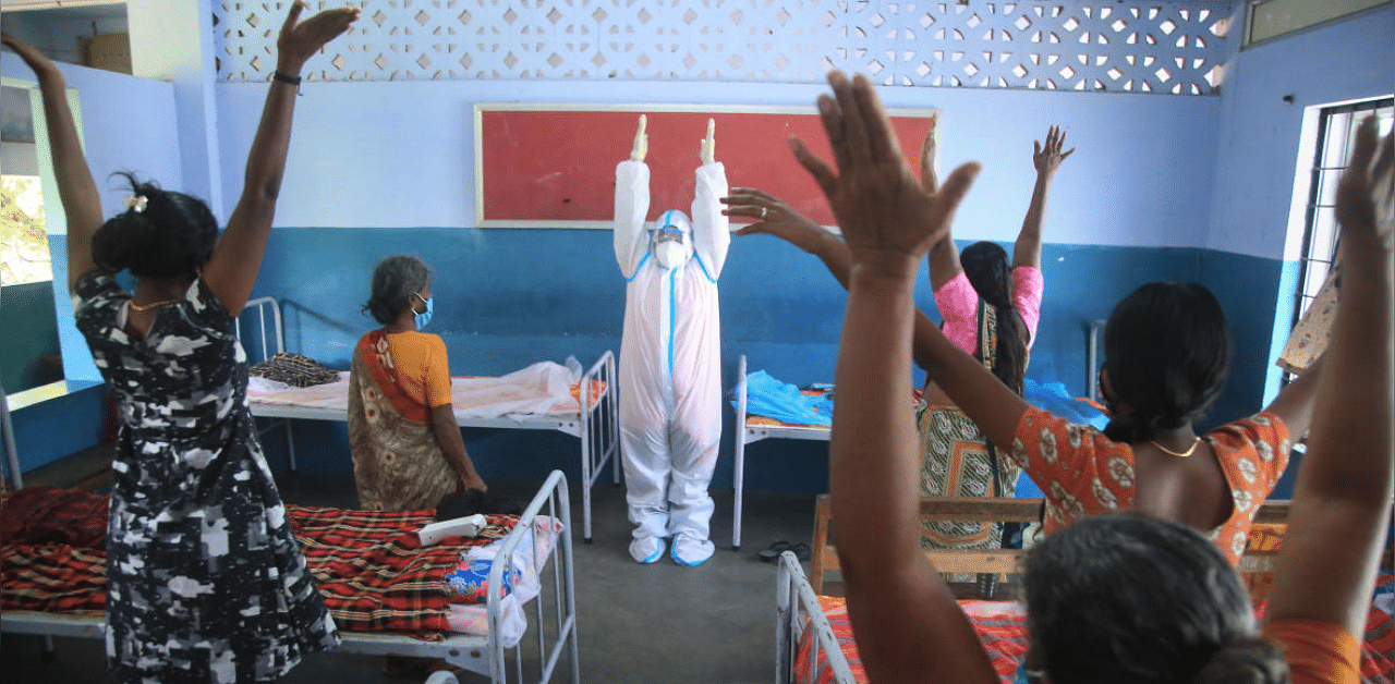 A Nagercoil Corporation worker wearing a PPE kit conducts yoga session at a Covid-19 care centre, in Kanyakumari district. Credit: PTI Photo