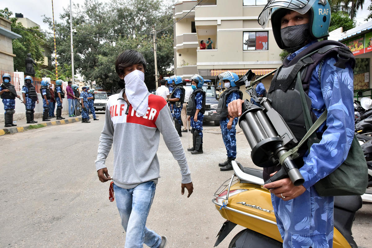 RAF personnel stand guard on Thursday at Kavalbyrasandra which witnessed riots on Tuesday. DH photo/Janardhan B K