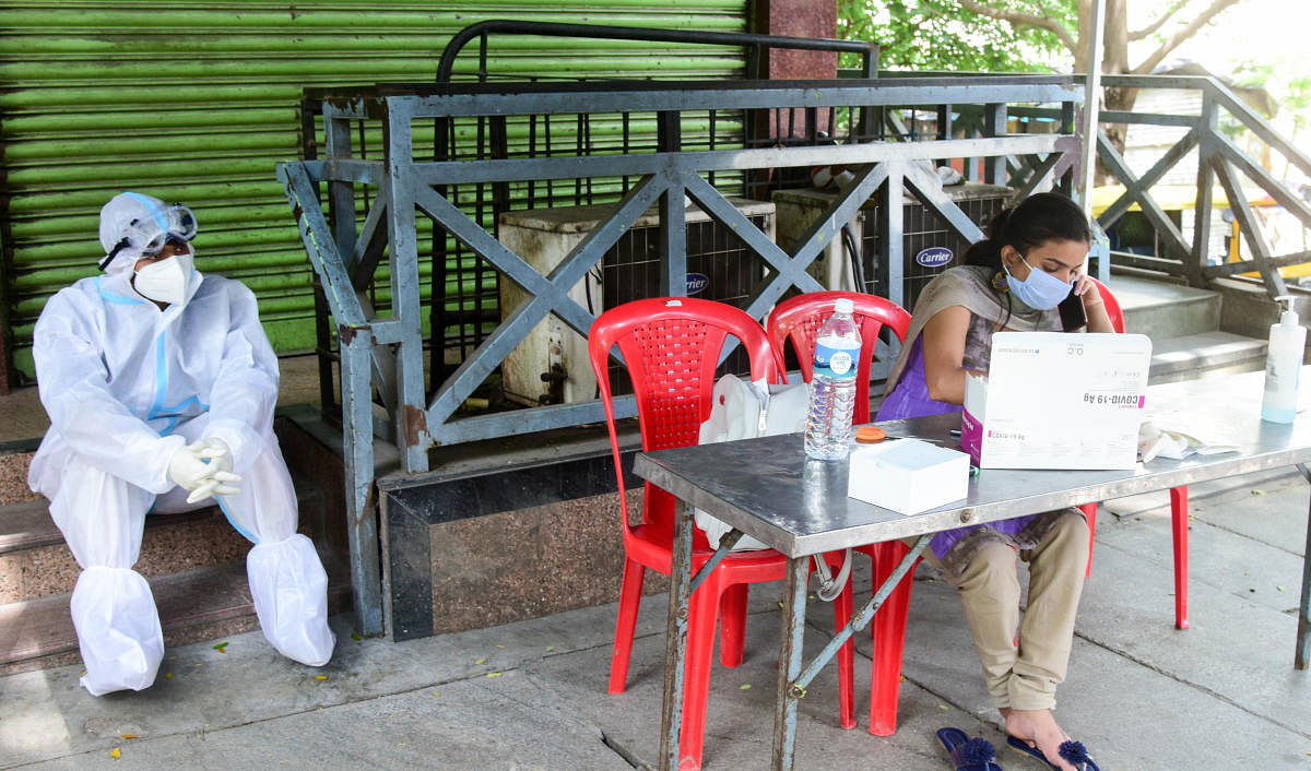 Health workers at a free Covid-19 testing booth in Bengaluru on Thursday. DH Photo/B H Shivakumar