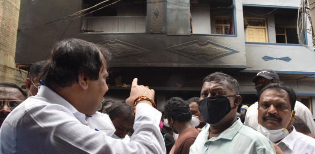 MLA Akhanda Srinivas Murthy points finger towards a burnt house at Kaval Byrsandra in Bengaluru. Credit: DH File Photo