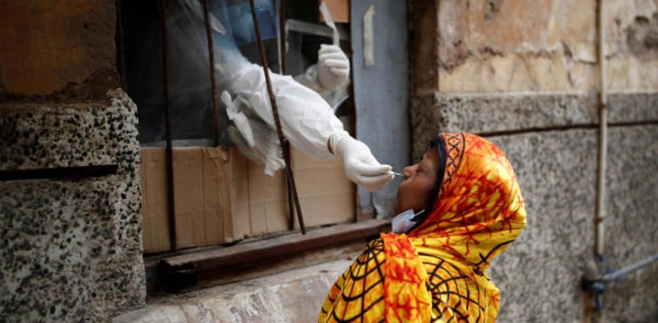 A health worker in personal protective equipment (PPE) collects a sample using a swab from a person at a local health centre to conduct tests for the coronavirus disease. Credit: Reuters