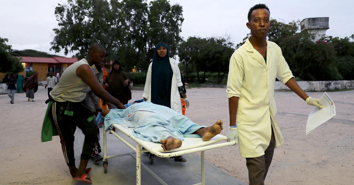Paramedics and civilians carry an injured person on a stretcher at Madina hospital after a blast at the Elite Hotel in Lido beach in Mogadishu, Somalia August 16, 2020. Credit: REUTERS