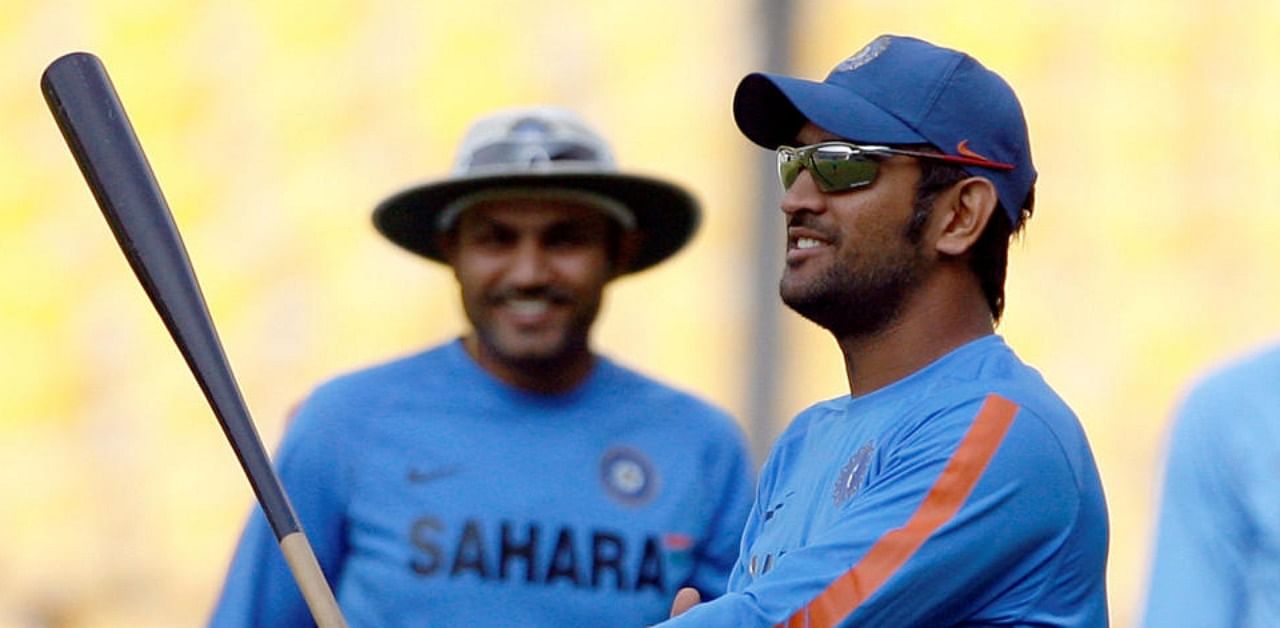India's captain Mahendra Singh Dhoni holds a baseball bat as team mates Virender Sehwag (L) and Yusuf Pathan (R) watch during a cricket training session in Nagpur December 8, 2009. (Reuters)