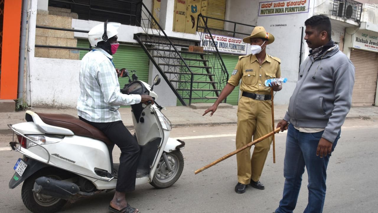 Policemen stop a motorist for questioning as he rides on Tannery Road, Bengaluru, on Sunday. DH PHOTO/S K DINESH