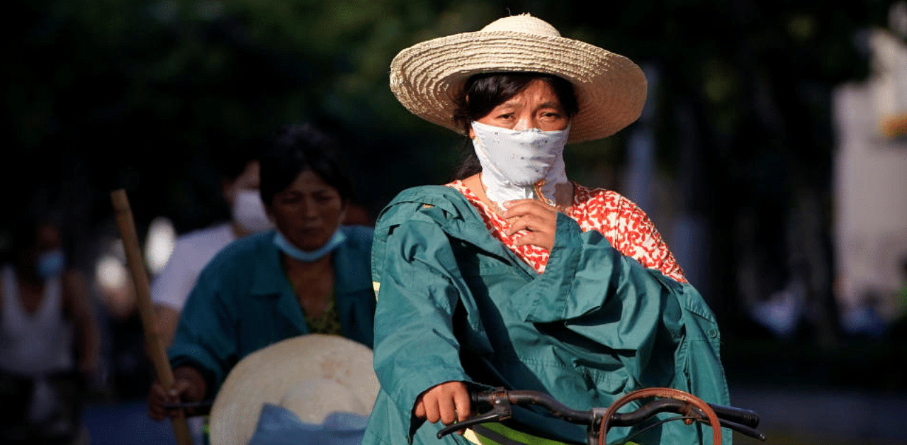 A woman wearing a mask is seen on a hot summer day, amid the coronavirus pandemic, in Shanghai, China. Credit: Reuters Photo