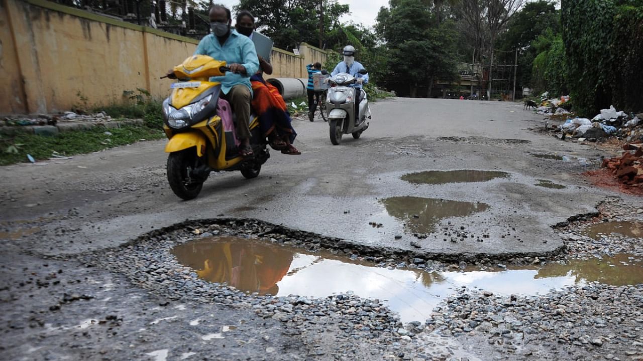 Motorists navigate a pothole at Shanthinagar. DH file/Pushkar V
