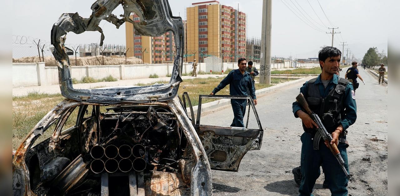 Afghan police officers inspect a vehicle from which insurgents fired rockets, in Kabul. Credits: Reuters