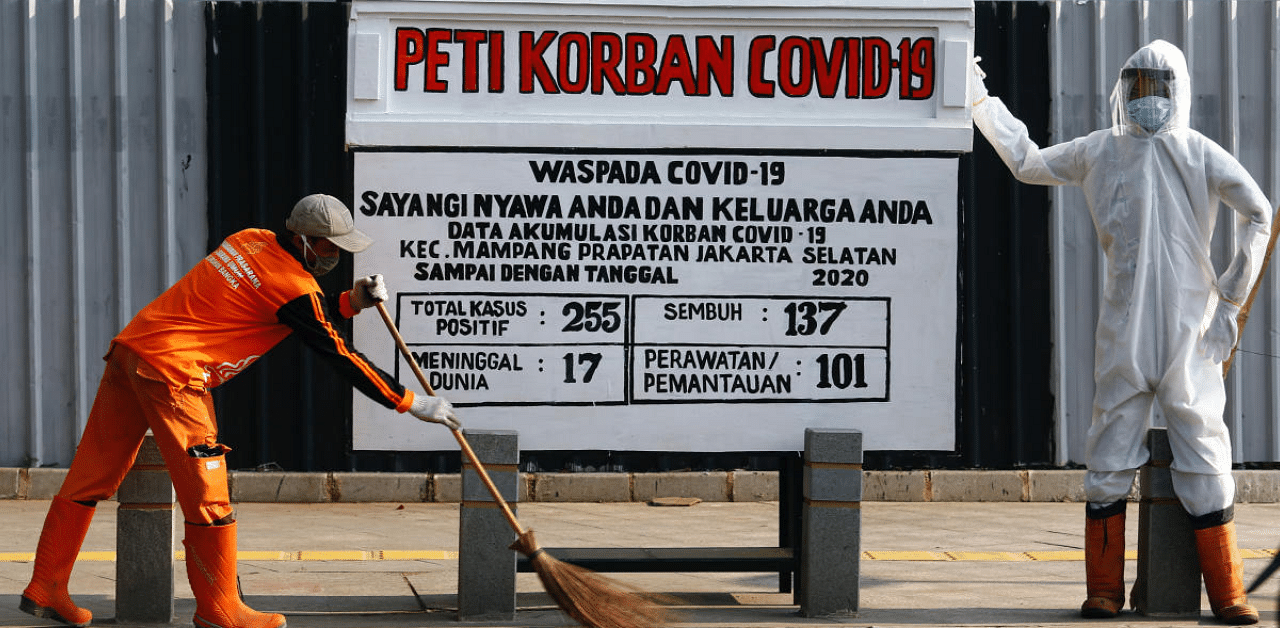 A worker sweeps near a mock coffin and a dummy dressed in a personal protective suit to resemble a health worker, in a public area to warn people about the dangers of the coronavirus disease (Covid-19) in Jakarta, Indonesia. Credit: Reuters Photo