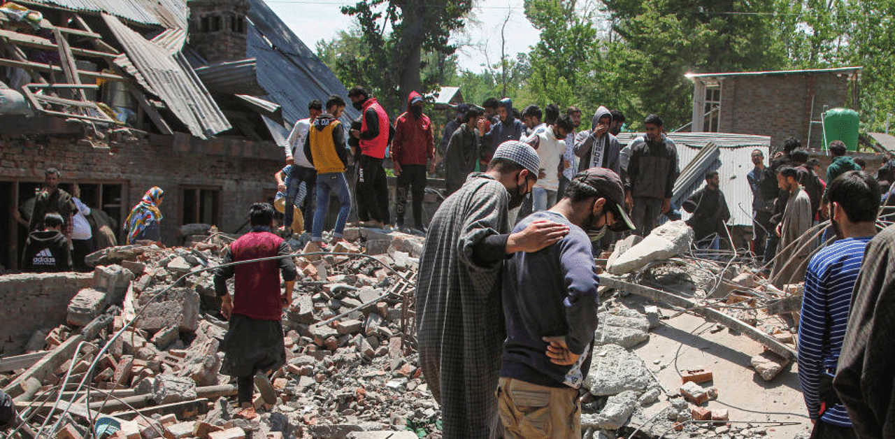 People inspect a house damaged after an encounter between security forces and militants at Melhora in Zainapora area of Jammu and Kashmir's Shopian district, Wednesday, April 29, 2020. Credit: PTI Photo