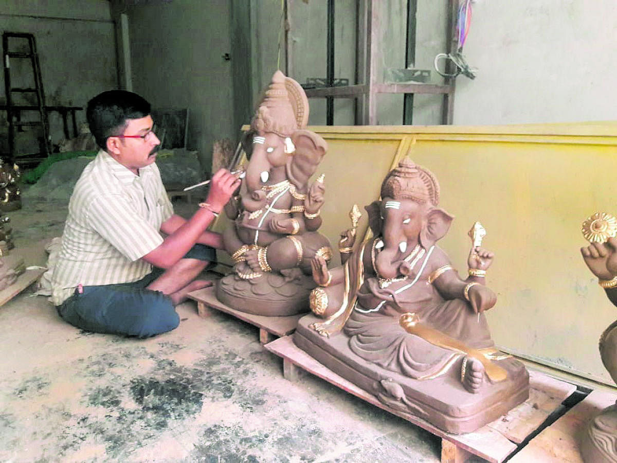 An artiste prepares Ganesha idols in Mysuru. 