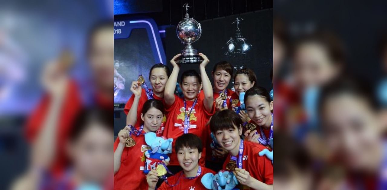Japan's Ayaka Takahashi holds up their winning trophy as she poses with her teammates. Credit: AFP
