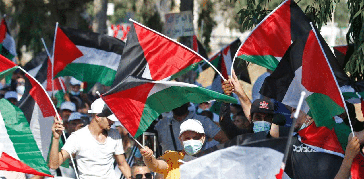 Palestinians wave national flags as they protest against the United Arab Emirates' decision to normalise ties with Israel, in the village of Turmus Aya near the occupied West Bank city of Ramallah on August 19, 2020.  Credit: AFP photo