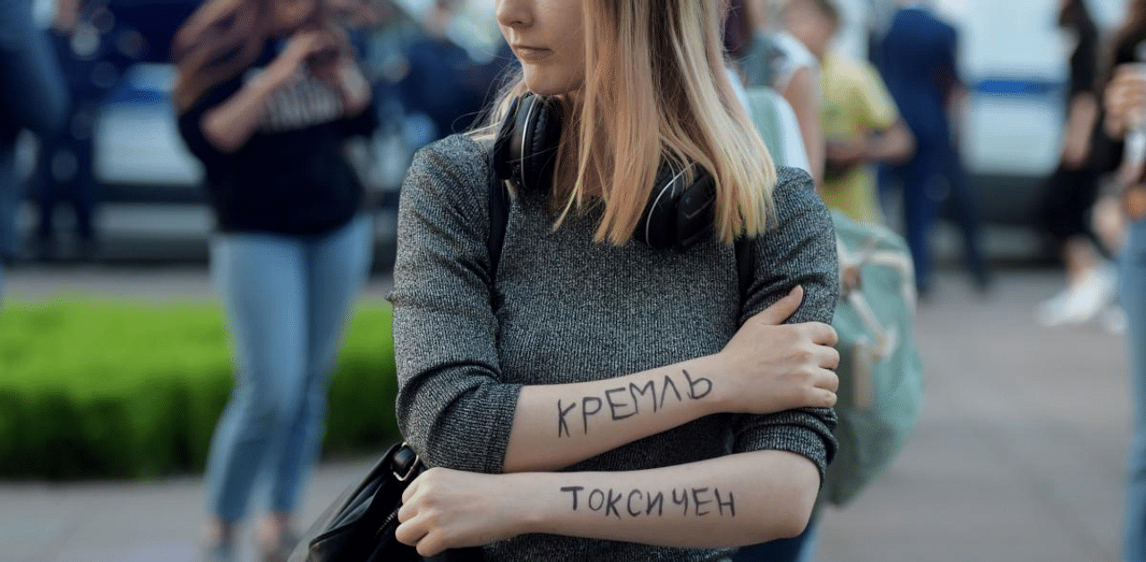 A woman with a lettering of her arms reading "The Kremlin is toxic" expresses support for Alexei Navalny after he was rushed to intensive care. Credit: AFP Photo