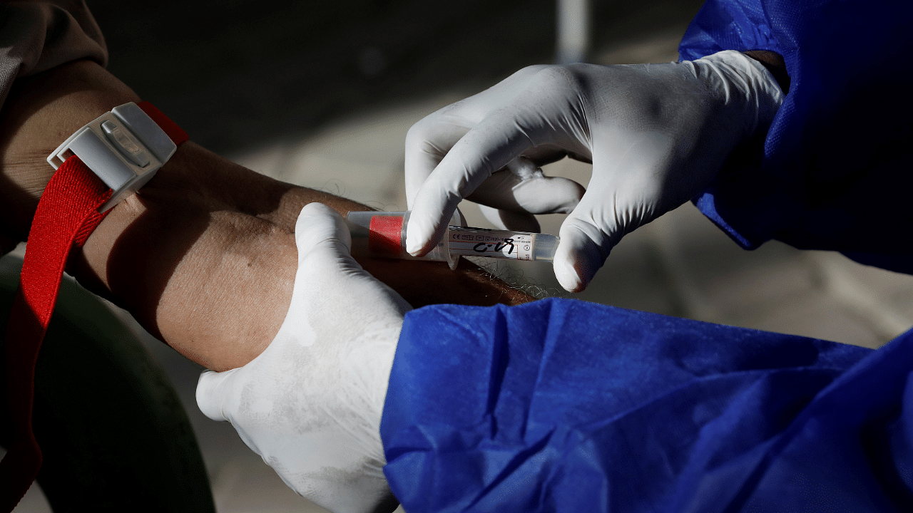 A paramedic wearing protective gloves takes a blood sample from a man to be tested for the coronavirus disease anti-body test. Credits: Reuters Photo
