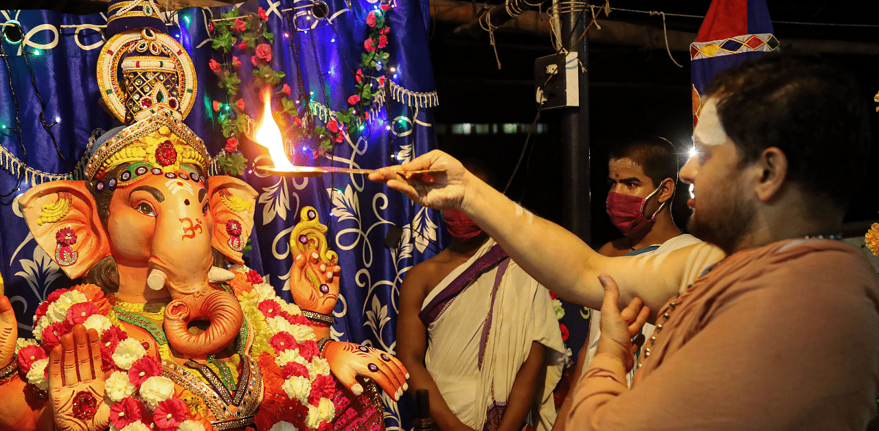 A priest performs 'aarti' in front of an idol of Lord Ganesh on the eve of Ganesh Chaturthi festival. Credit: PTI Photo
