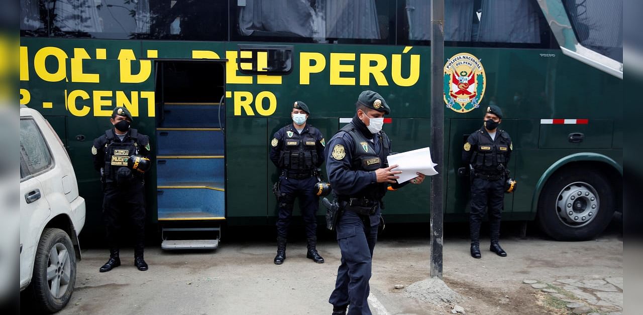 Police officers stand guard outside a bus with people who were detained when a nightclub was raided for hosting a party in violation of the coronavirus disease restrictions. Credits: Reuters