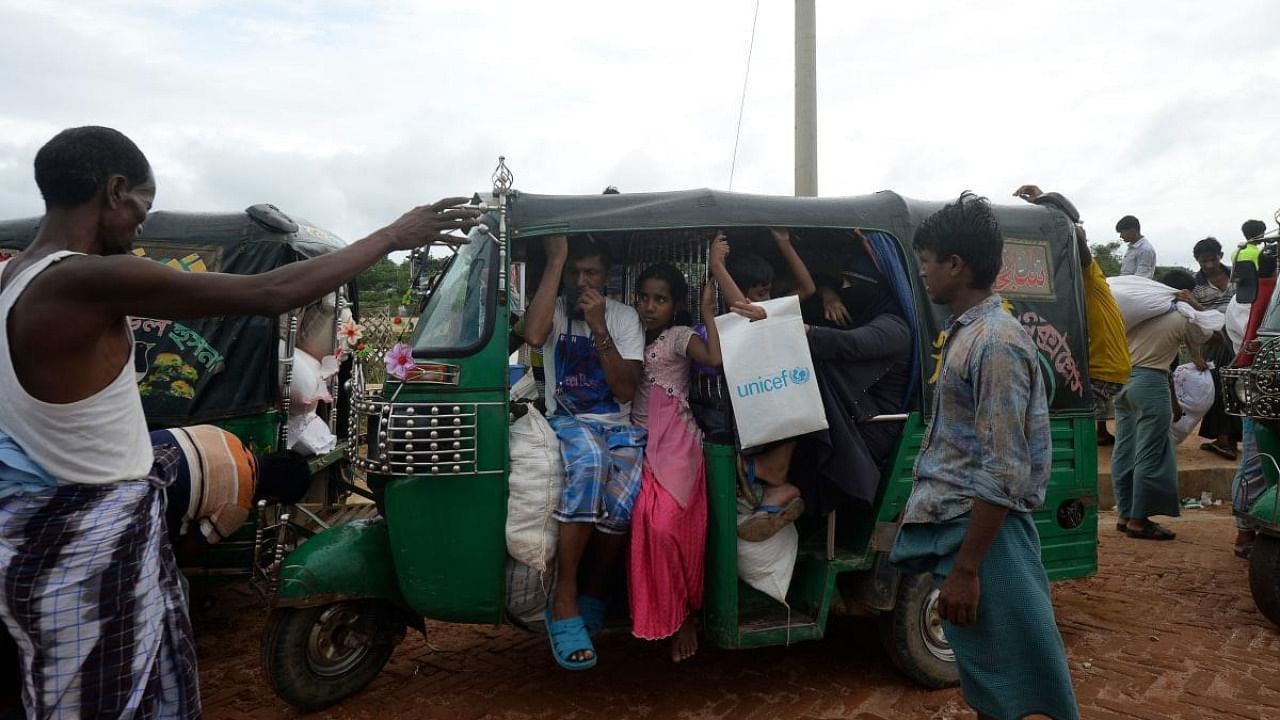 Rohingya people board on a three wheeler after collecting relief material in Kutupalong refugee camp, in Ukhia. Credit: AFP