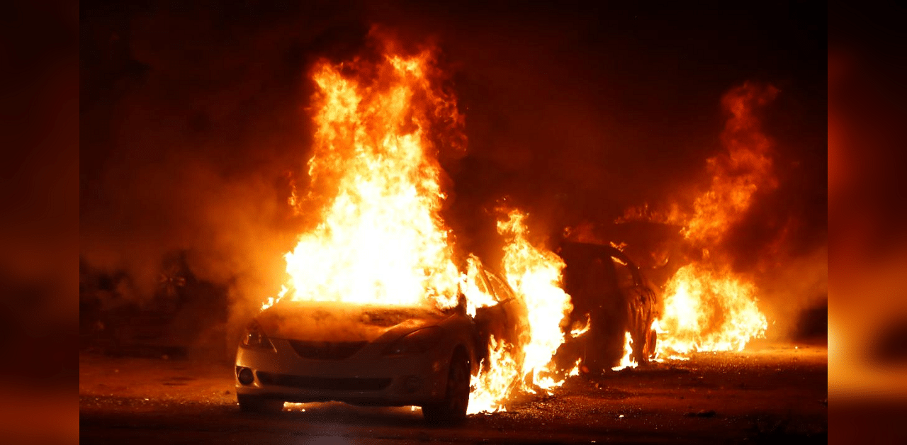 Flames roar from cars torched by protestors a few block from the County Court House during a demonstration against the shooting of Jacob Blake. Credit: AFP