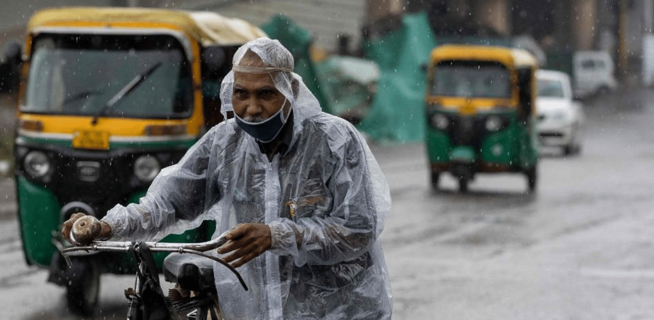 A man pushes his bicycle along a street during monsoon rainfalls in New Delhi. Credit: AFP