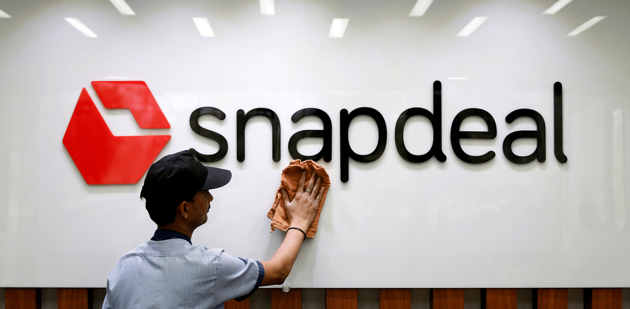 An employee cleans a Snapdeal logo at its headquarters in Gurugram on the outskirts of New Delhi. Credit: Reuters Photo