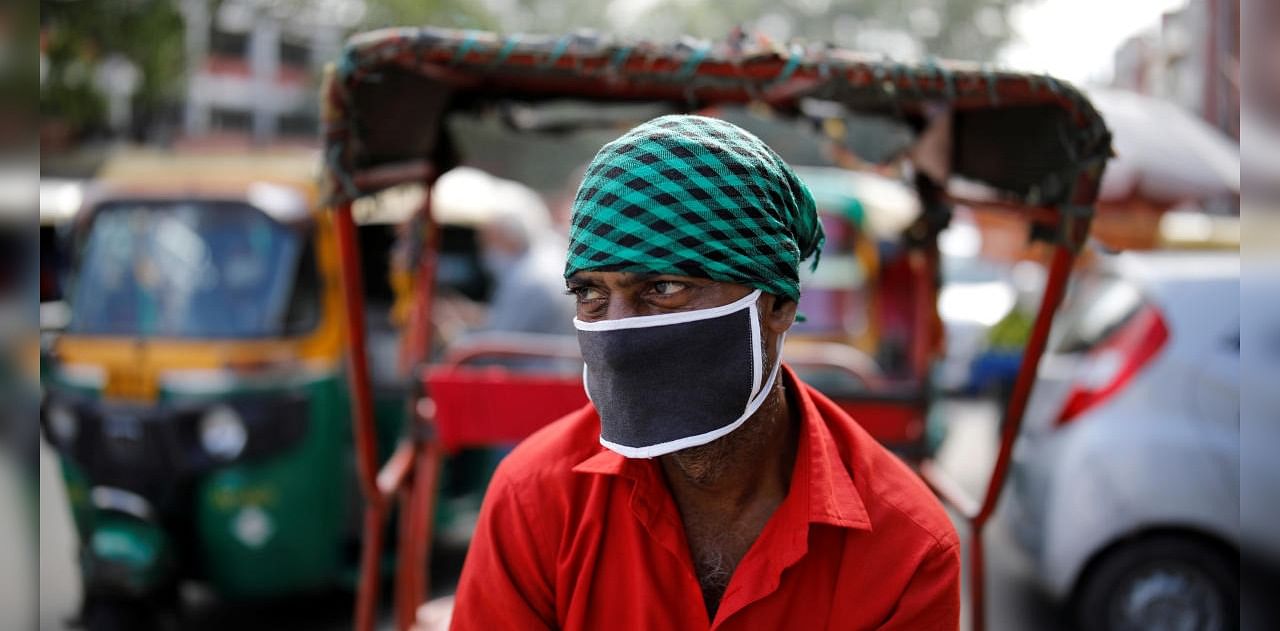 A rickshaw puller wearing a protective face mask waits for customers on a street, amidst the spread of coronavirus disease in the old quarters of Delhi, India, August 24, 2020. Credit: Reuters Photo