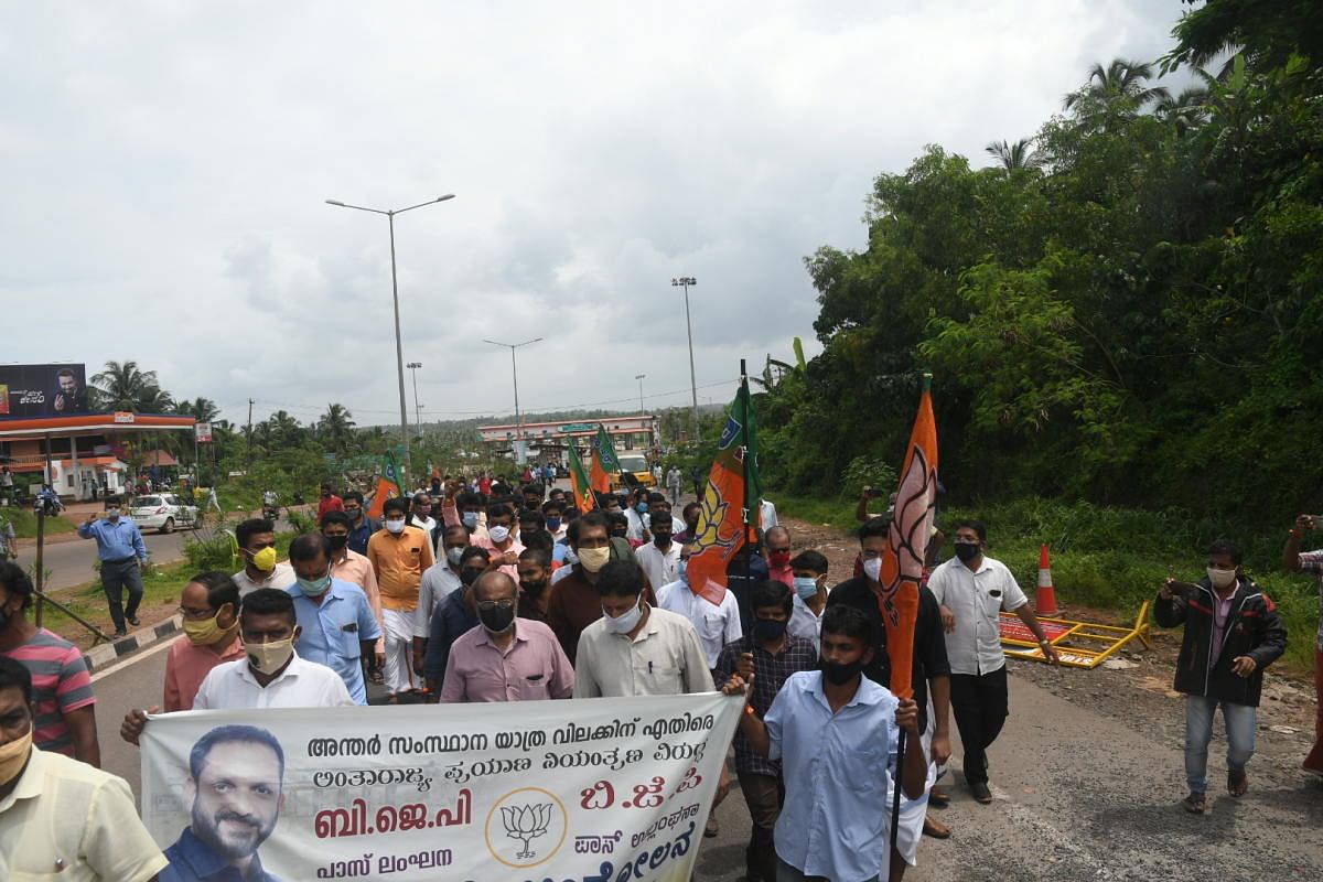 Kasargod BJP unit members stage a protest demanding free interstate movement of people and goods without any restriction at Talapady.