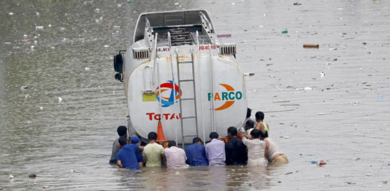 Men push a truck through a flooded road during monsoon rain, as the outbreak of the coronavirus disease (Covid-19) continues, in Karachi, Pakistan. Credit: Reuters Photo