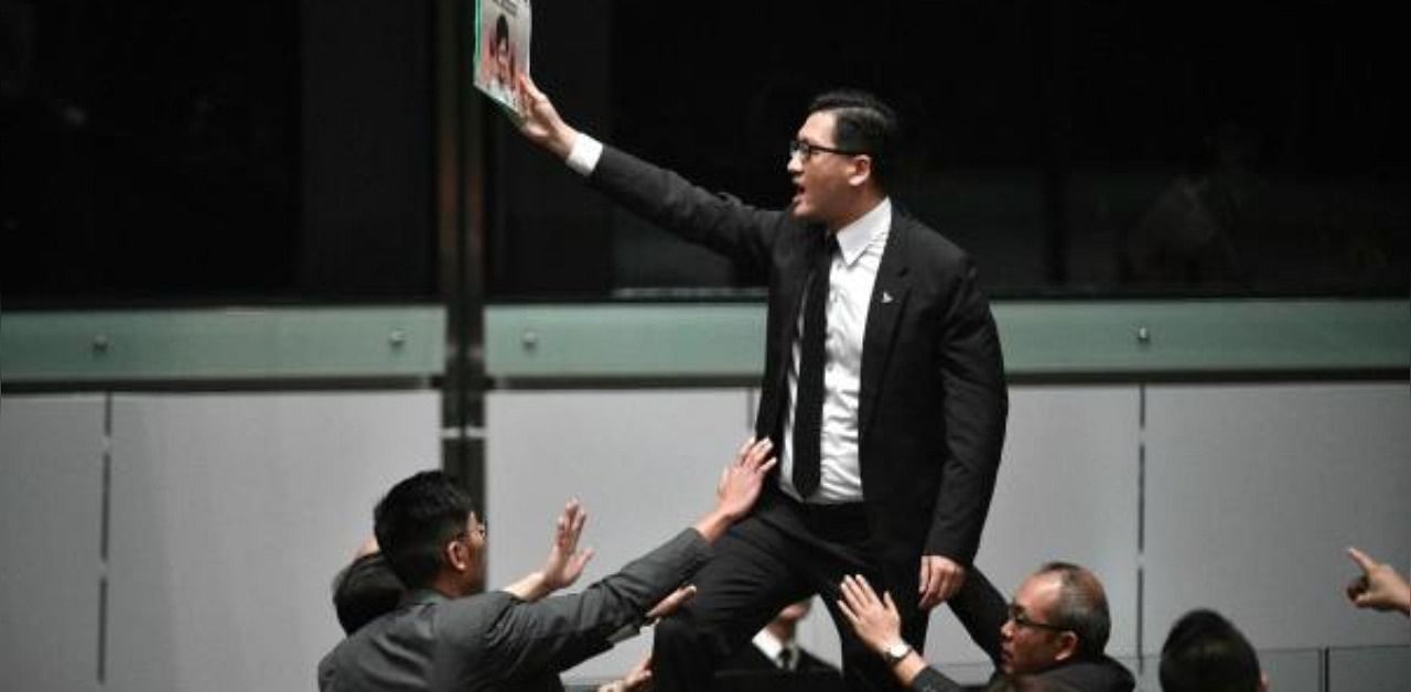 Pro-democracy lawmaker Lam Cheuk-ting (C) stands up and protests shortly before Hong Kong's Chief Executive Carrie Lam (not pictured) leaves the chamber for the second time while trying to present her annual policy address at the Legislative Council (Legco) in Hong Kong. Credit: AFP Photo