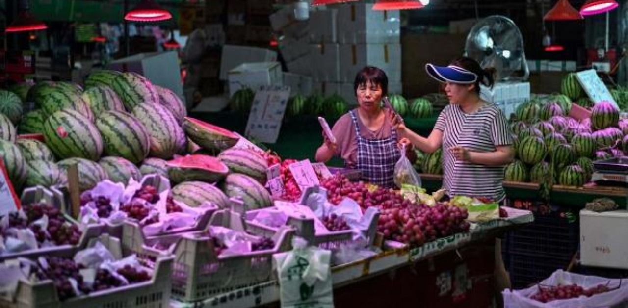 a woman buying fruit at the Huahuan Zhenbei agricultural products market in Shanghai. Credit: AFP Photo