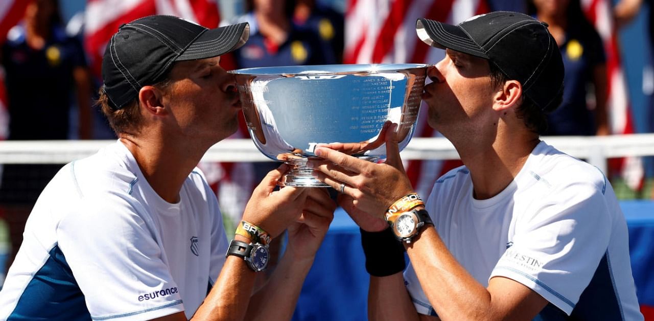 Bob Bryan (L) and his brother Mike Bryan kiss their trophy after they defeated Marcel Granollers and Marc Lopez of Spain in their men's doubles final at the 2014 US Open. Credits: Reuters