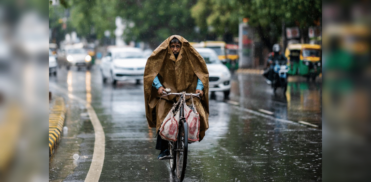 A man commutes on a bicycle during monsoon rainfalls in New Delhi. Credit: AFP