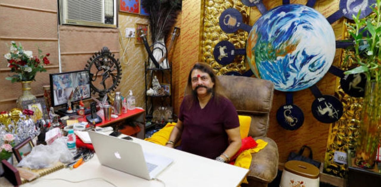 Sanjay Sharma, a mystic healer and astrologer, sits inside his office as he waits for a next client, amidst the spread of the coronavirus disease. Credit: Reuters
