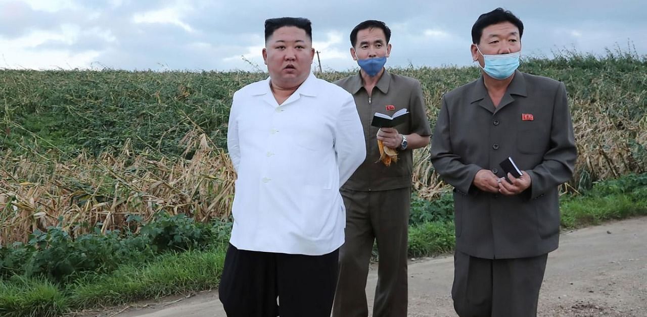 North Korean leader Kim Jong Un (L) visits typhoon-stricken area in South Hwanghae Province. AFP PHOTO/KCNA VIA KNS 