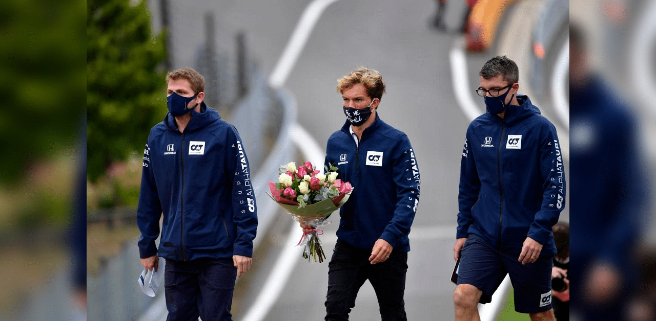 AlphaTauri's French driver Pierre Gasly (C) carries a bouquet of flowers to leave at the site where late French racing driver Anthoine Hubert had an accident at the Spa-Francorchamps circuit in Spa. Credit: AFP