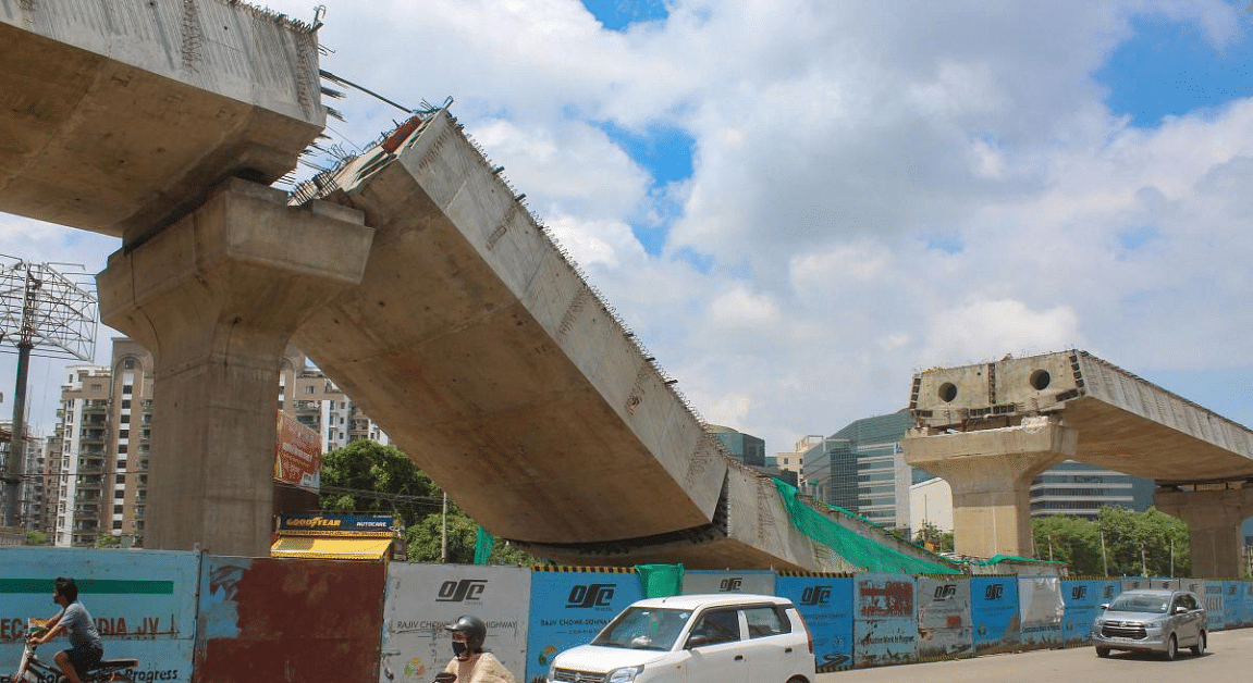 Commuters ride past the collapsed section of the under-construction flyover, at Sohna road in Gurugram, Sunday, Aug 23, 2020. Credit: PTI Photo