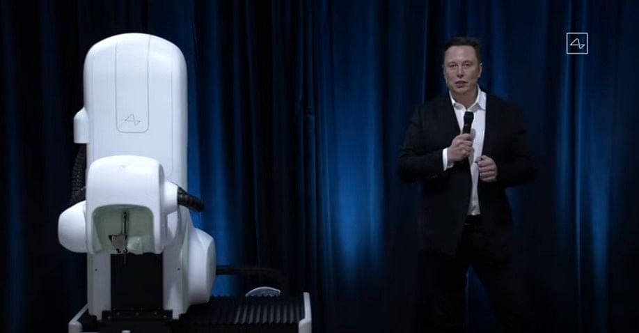 Elon Musk with Neuralink device trans planter machine. Credit: Neuralink/YouTube