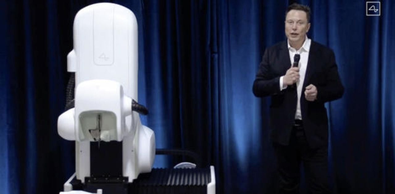 Elon Musk standing next to the surgical robot during his Neuralink presentation. Credit: AFP Photo