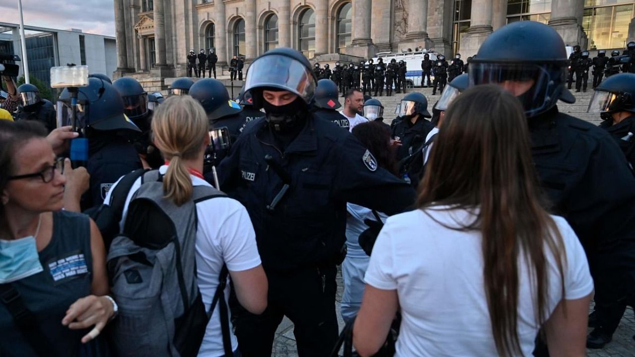 German riot policemen clear the area in front of the Reichstag building from protesters after the end of a demonstration called by far-right and Covid-19 deniers to protest against restrictions related to the new coronavirus pandemic, in Berlin. Credit: AFP